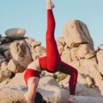 woman doing yoga near rock during daytime